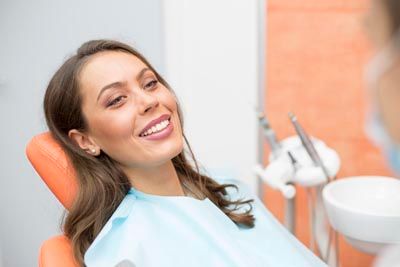 woman smiling after getting an oral surgery procedure at Pacific Coast Dentistry in Paso Robles, CA