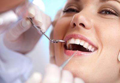 Woman smiling during dental exam with mirror